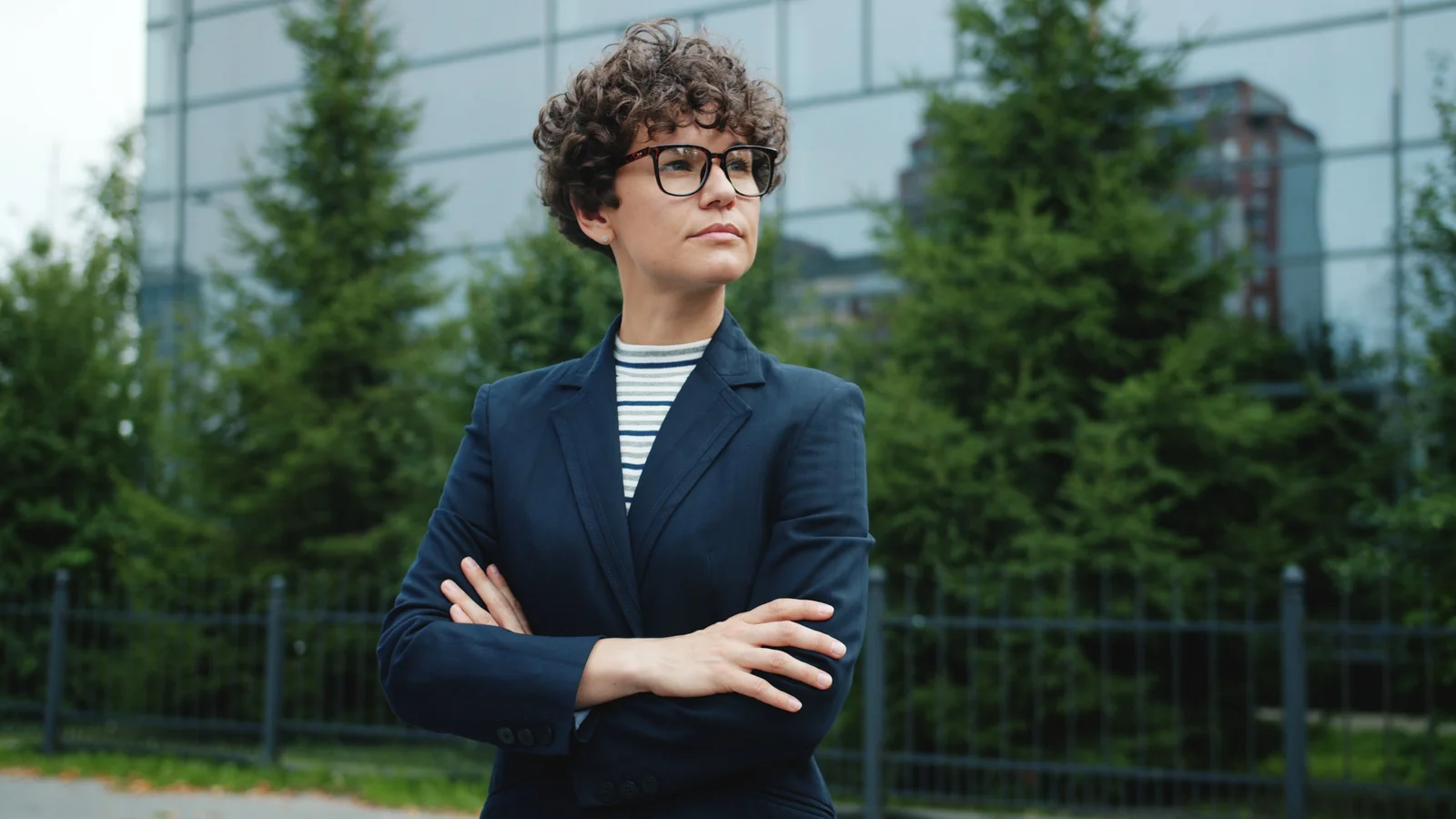 Blazer bleu marine ouvert sur un haut rayé clair