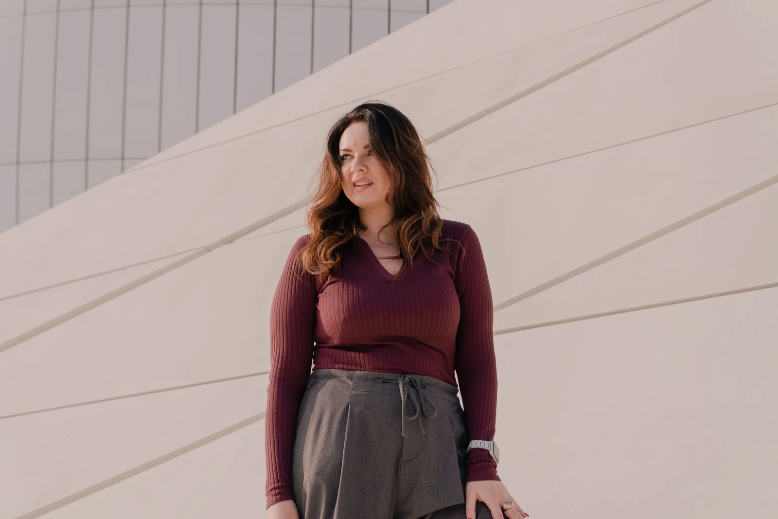 Haut bordeaux porté avec un pantalon gris